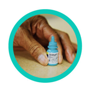 Removing the cap of an eye drop medicine bottle carefully.